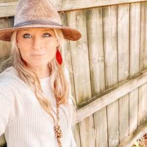 Jessica Taylor in front of a wooden fence